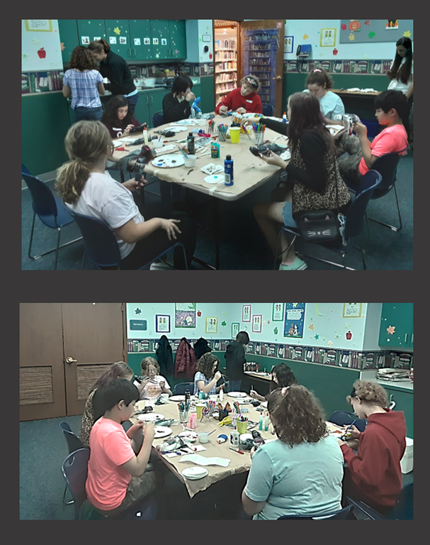Working on docorating our dolls Youth sitting around table with crafting supplies, painting dolls