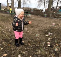 Toddler catching bubbles